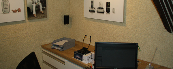 Modernes Home-Office mit Schreibtisch, Computer und Wandbildern zu Telekommunikation.