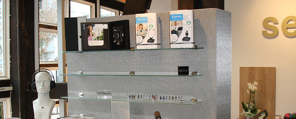 Präsentation von Hörgeräte-Zubehör, Kopfhörer und Pflegeprodukten in einem modernen Geschäft.